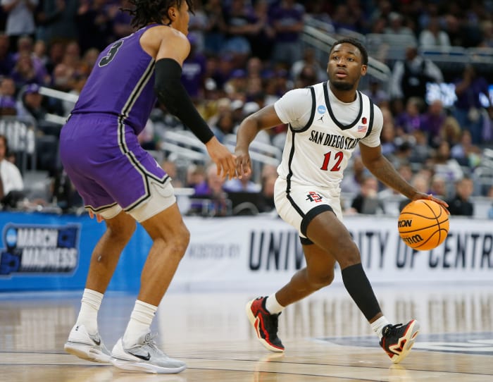 San Diego State Aztecs guard Darrion Trammell dribbles against Furman Paladins guard Mike Bothwell.
